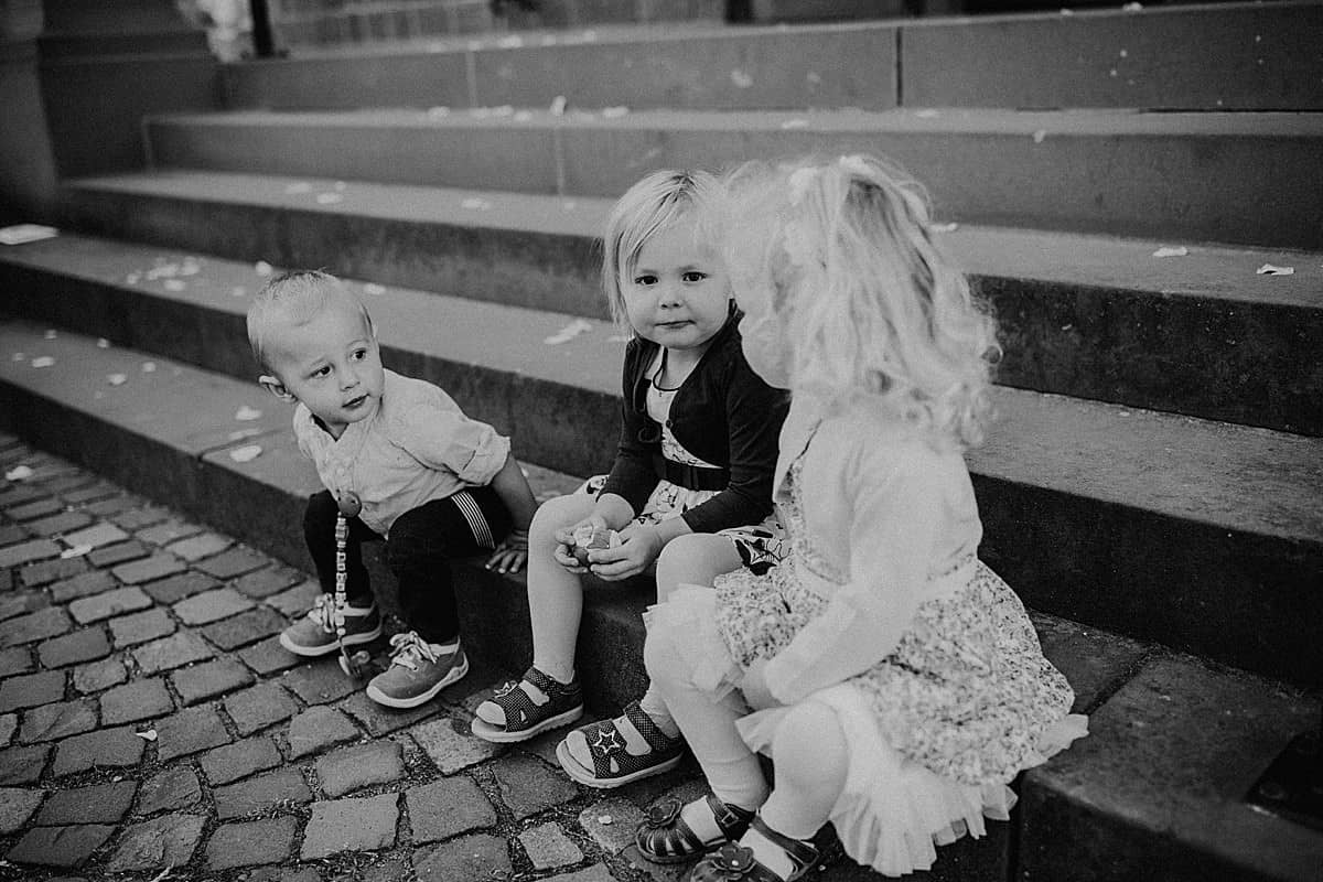 Hochzeitsfotograf im Saarland und der Pfalz - kleine Momente spielende Kinder auf der Treppe Kirche Maxdorf